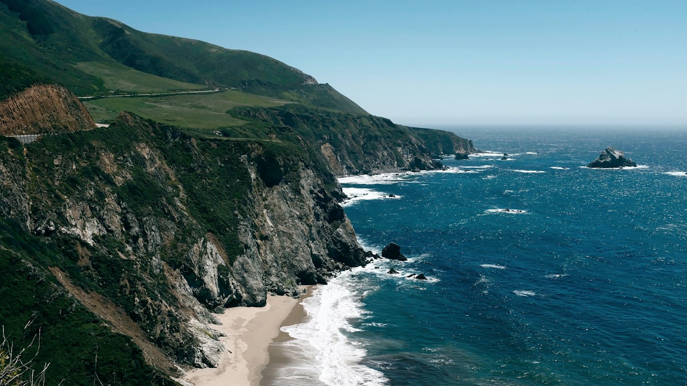 Pacific waves meeting the rugged green cliffs of Big Sur